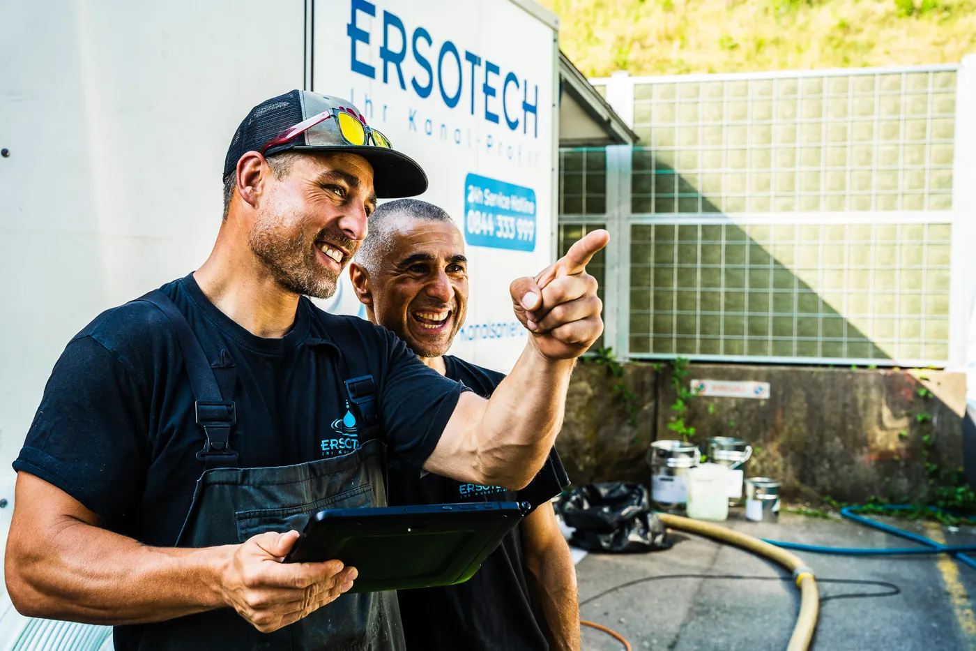 Two sewer specialists reviewing inspection results on a tablet