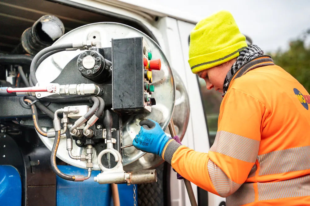 Operator handling the hose reel of a cleaning truck