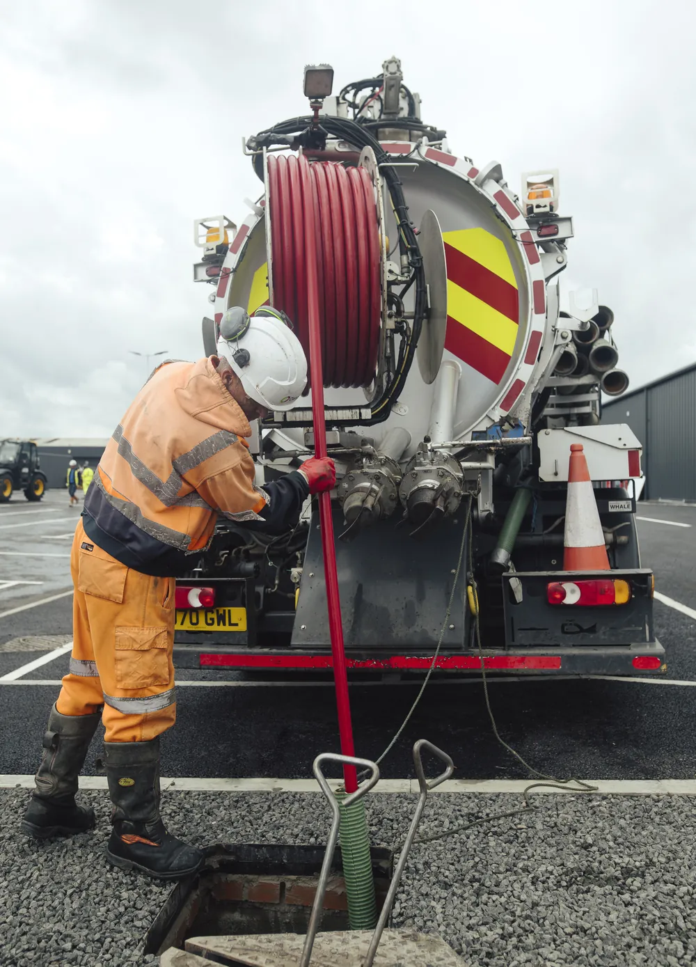 Specialist jetting a drain from a combination truck