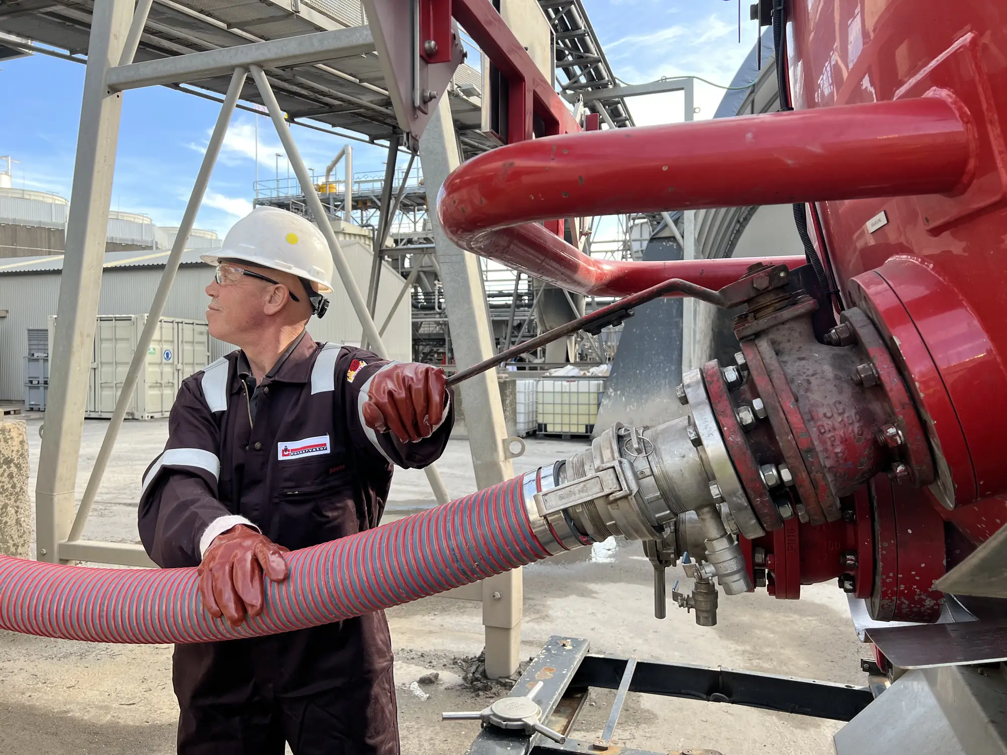 Industrial cleaning specialist connecting a suction hose at a plant