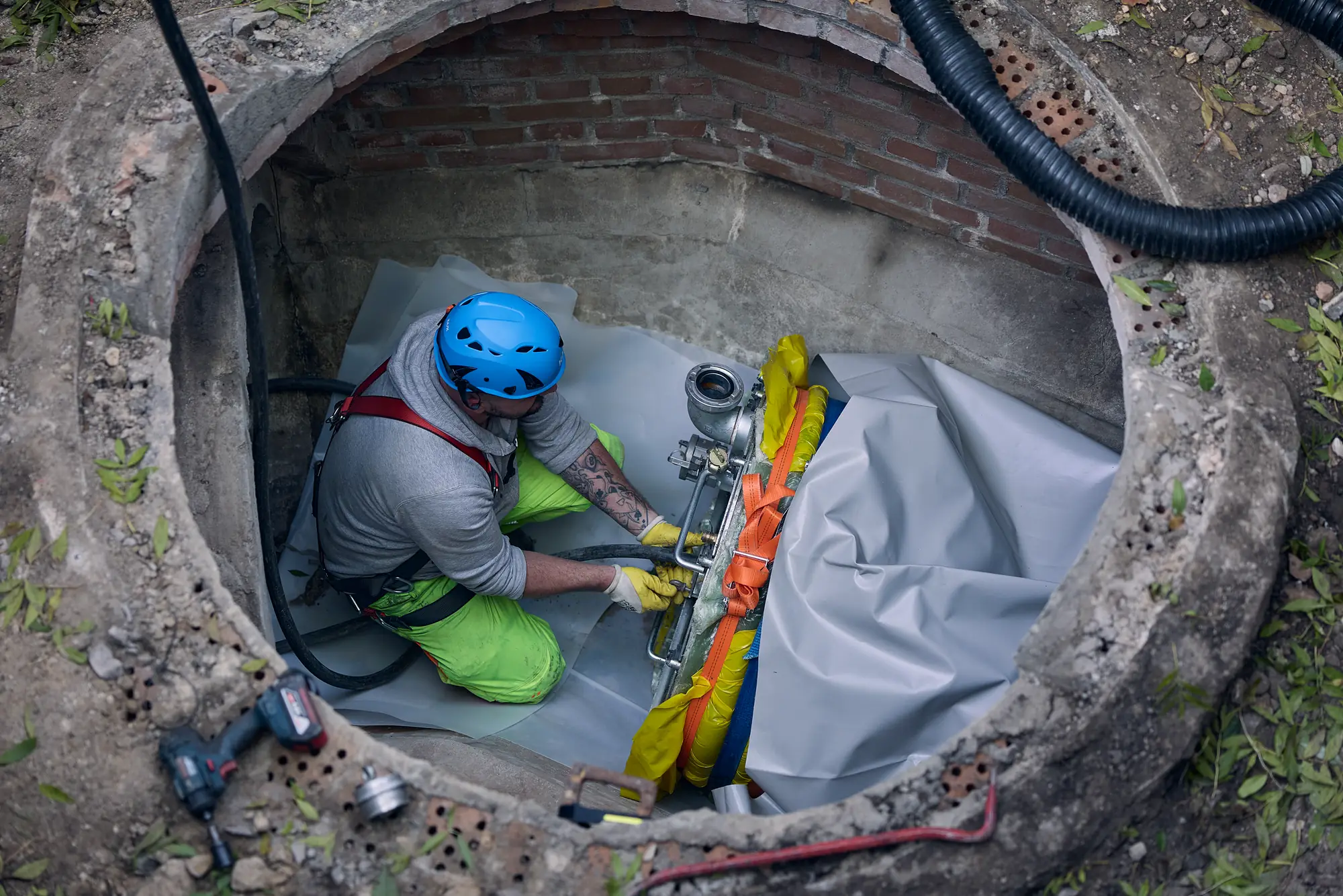 Specialist installing a sewer liner inside a manhole