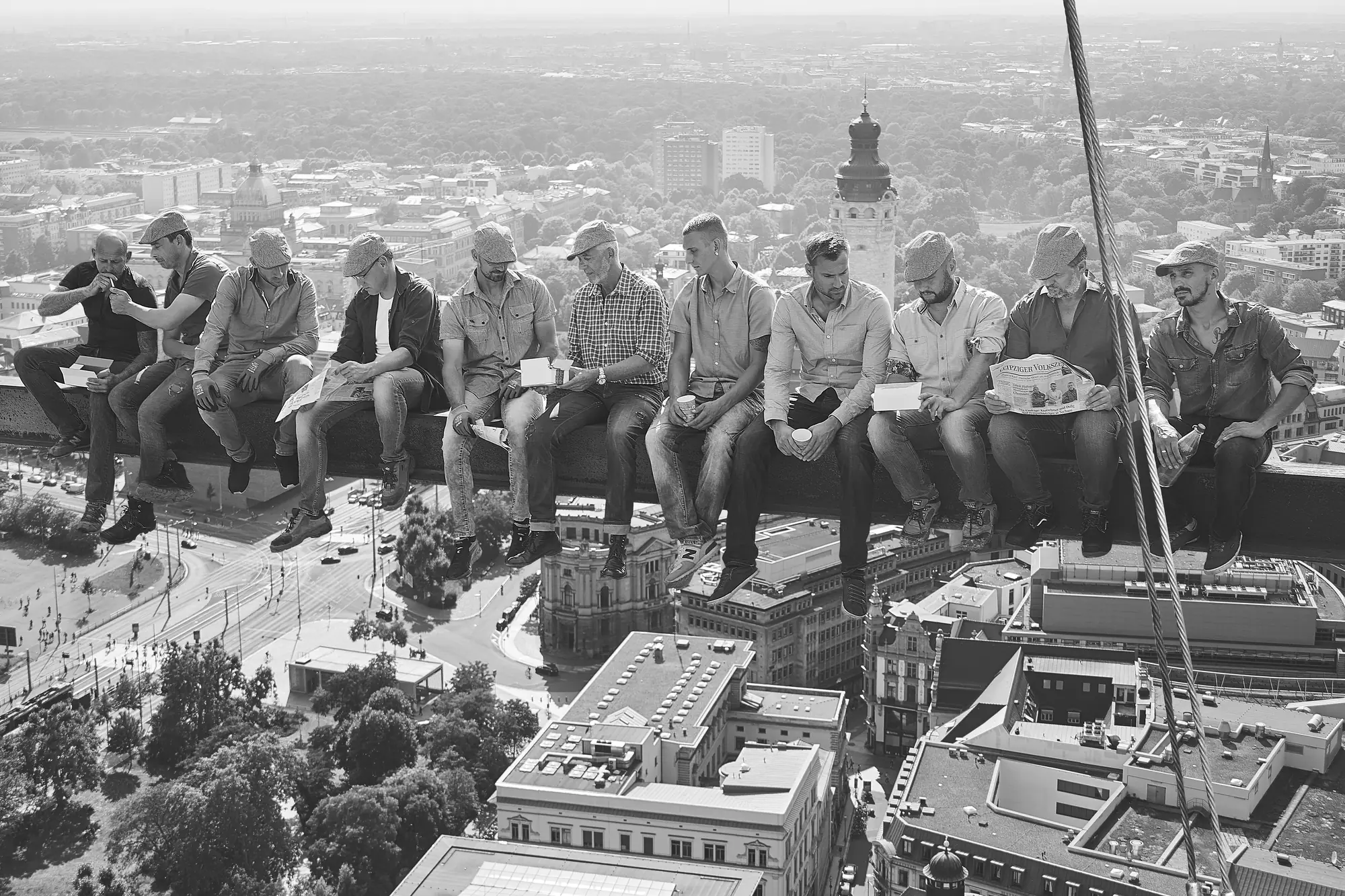 KSG team sitting together on a steel beam high above the city