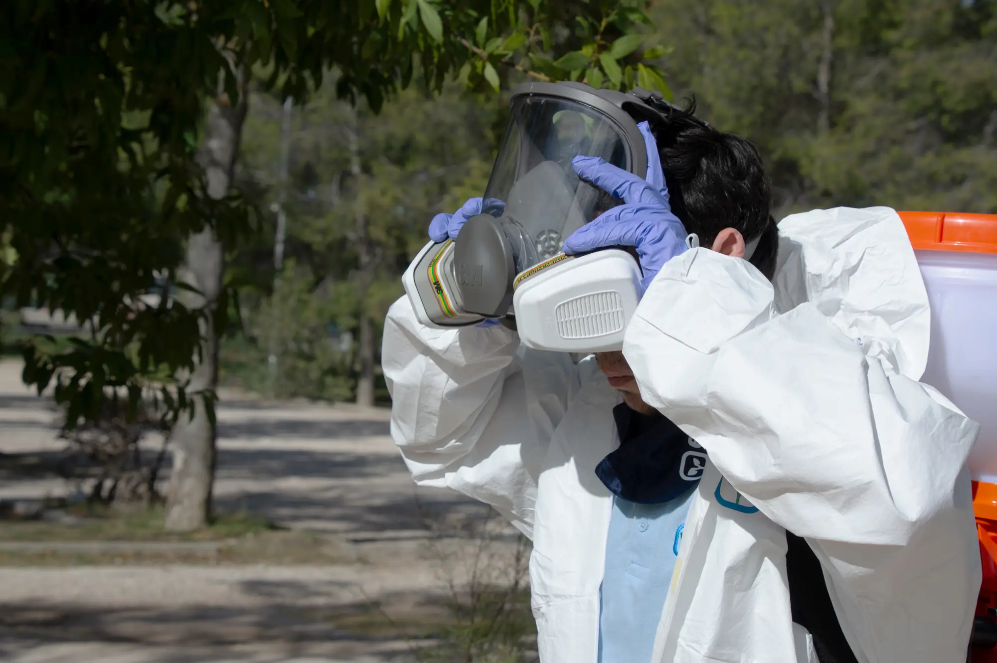 Technician putting on a respirator before a treatment