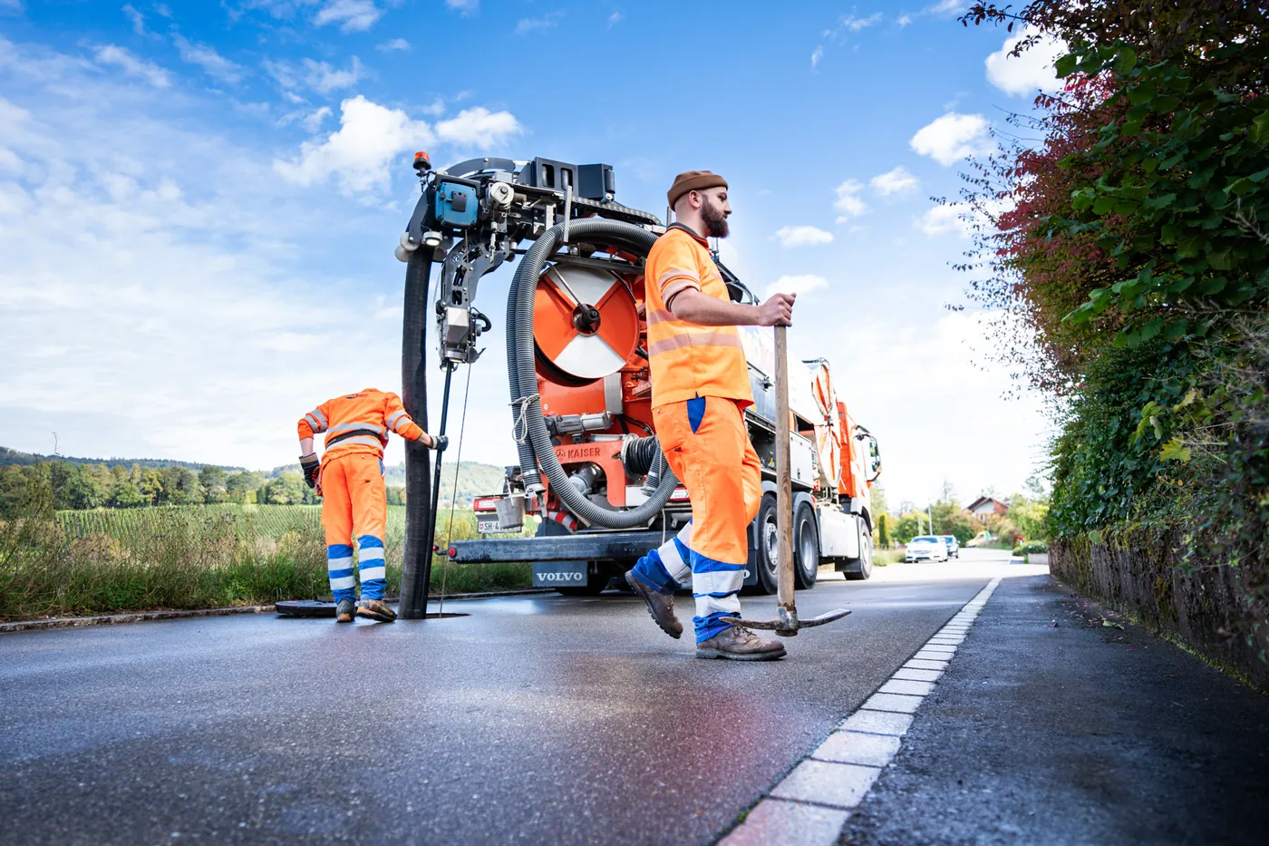 Sewer-cleaning truck and operator at work on a village road