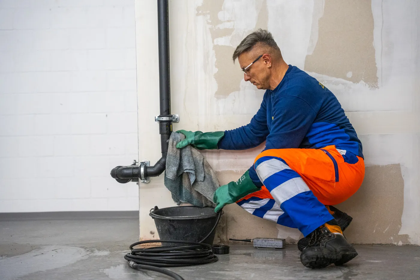 Technician renovating drainage pipes inside a building