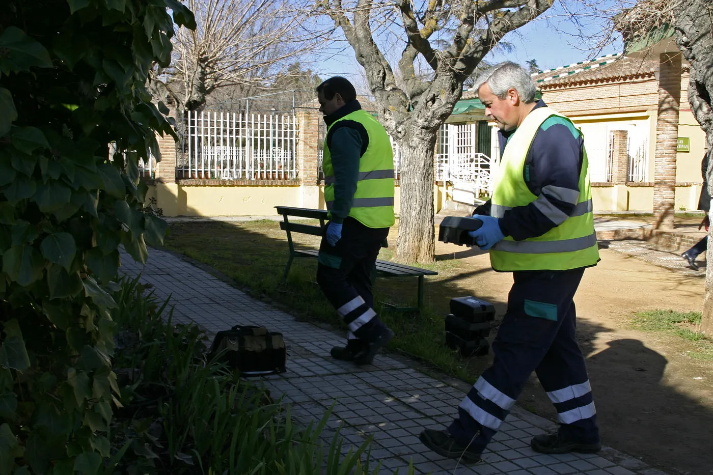 Two technicians carrying out outdoor rodent control in a park