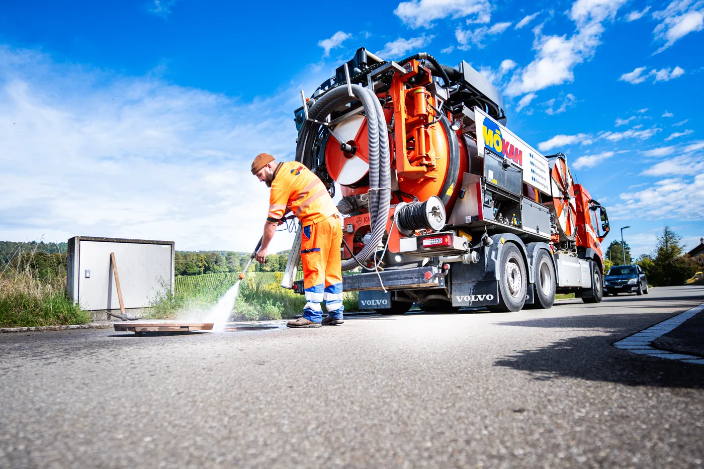 Operator jetting a sewer next to a combination truck