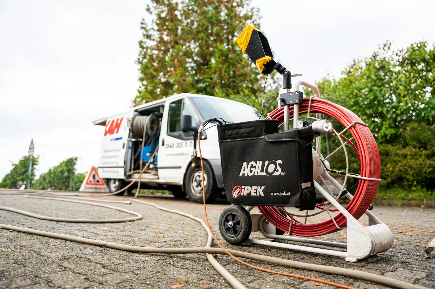 Sewer inspection camera reel next to a service van